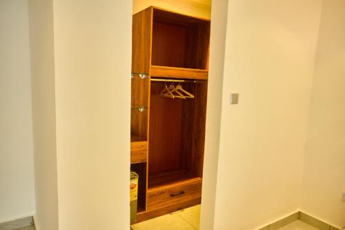 a walk in closet with a wooden cabinet at AIDEN HOMES AND APARTMENTS HOTEl in Koforidua