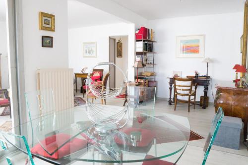- une table en verre dans le salon avec des chaises dans l'établissement EXIGEHOME appartement de standing a 10 minutes du Chateau, à Le Chesnay