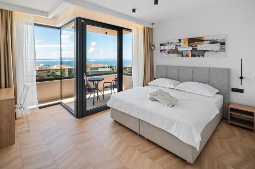 a bedroom with a bed and a balcony at NEW! Villa Pavuza – Luxury 4-Bedroom Seaview Villa in Podstrana