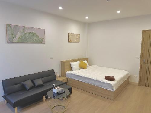a bedroom with a bed and a couch at Happy Home - Big Balcony - Best Location in Hanoi
