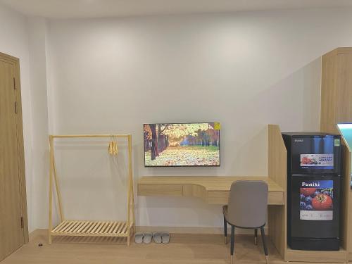 a room with a desk with a television on a wall at Happy Home - Big Balcony - Best Location in Hanoi