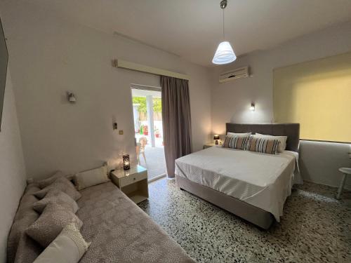 a bedroom with a bed and a couch at Nikos Studios in Keri