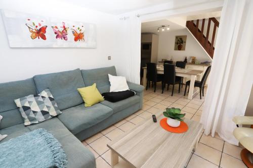 un salon avec un canapé bleu et une table dans l'établissement Belle villa T3 avec terrasse proche de la plage de St Cyprien, à Saint-Cyprien