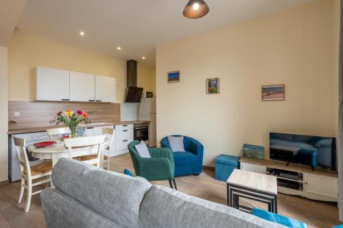 un salon avec un canapé et une table et une cuisine dans l'établissement Lakme - 2min à pied de la Plage, à Mers-les-Bains