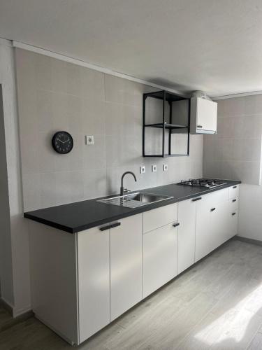 a kitchen with white cabinets and a sink at Villa`s Safara in Safara
