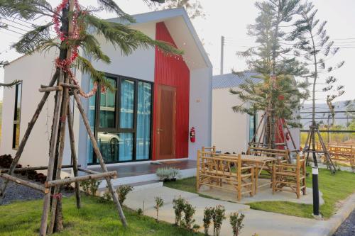 a house with a red door and a patio at myrrh Resort เมอร์รีสอร์ท in Ban Nong Kop
