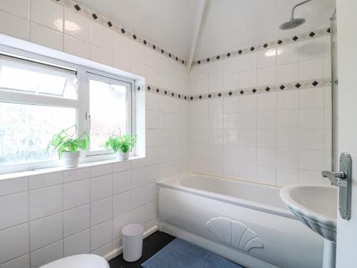 a white bathroom with a tub and a sink at 46 Dalby Road in Leicester