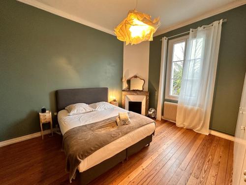 a bedroom with a bed and a fireplace and a window at Tropical House in Bordeaux
