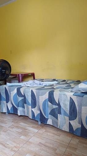 a bed with a blue and white comforter in a room at Brito Hospedagem in Barreirinhas