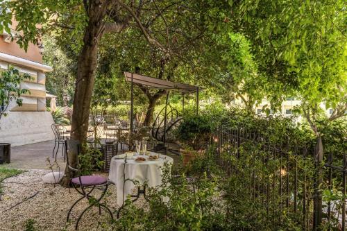 a table and chairs under a tree in a garden at Mangili Garden Hotel in Rome