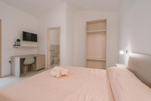 a bedroom with a bed with a pink towel on it at Affittacamere Avedí in Siniscola