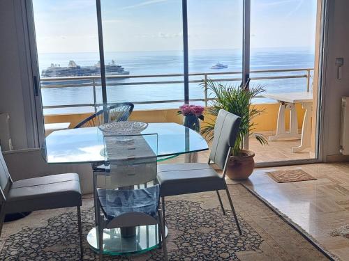 une table et des chaises dans une pièce avec vue sur l'océan dans l'établissement MONACO - LUXURY APARTMENT Fantastic Sea View- 1 bedroom, à Roquebrune-Cap-Martin