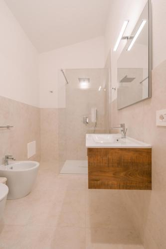 a bathroom with a sink and a toilet and a mirror at Affittacamere Avedí in Siniscola