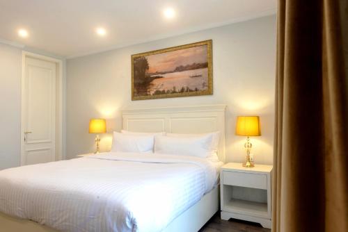 a bedroom with a white bed and two lamps at PC Residences Gulberg Lahore in Lahore