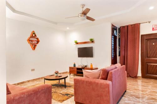 a living room with a couch and a tv at AIDEN HOMES AND APARTMENTS HOTEl in Koforidua