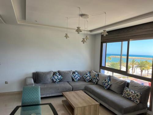 a living room with a couch and a view of the ocean at PUERTO MARINA ASILAH in Asilah