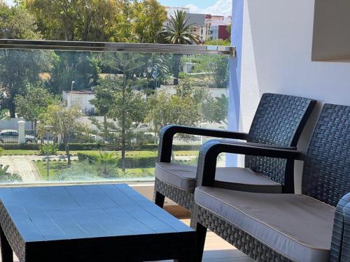two chairs and a table in front of a window at PUERTO MARINA ASILAH in Asilah