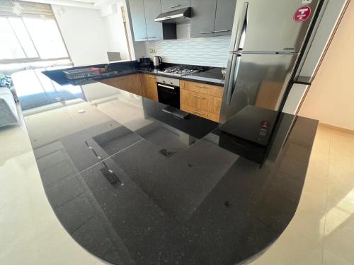 a kitchen with a stainless steel refrigerator and cabinets at PUERTO MARINA ASILAH in Asilah