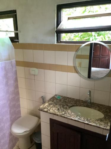 a bathroom with a sink and a toilet and a mirror at Casa Rústica com piscina in Pirenópolis
