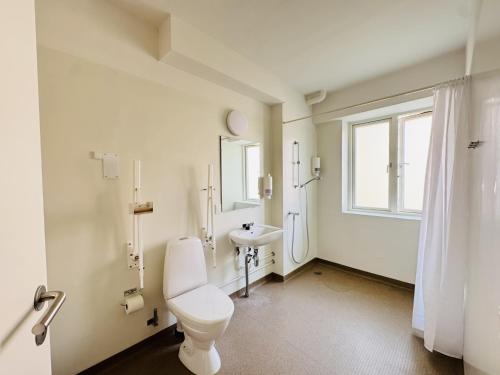 a bathroom with a toilet and a sink and a window at aday - Lodsejervej Suite 4 in Randers