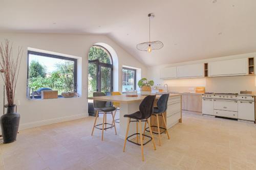 a kitchen with a table and chairs in it at Chambre Comfort - Ancien Cuvage des Pierres Dorée in Denicé