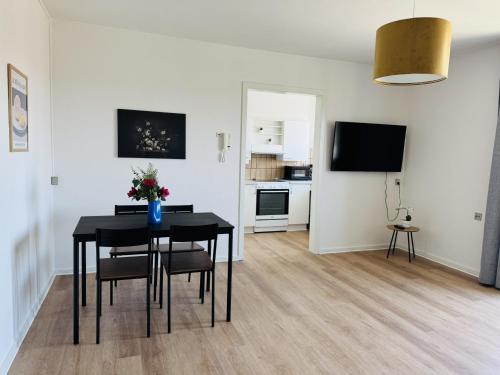 a living room with a dining room table and a kitchen at aday - Lodsejervej Suite 1 in Randers