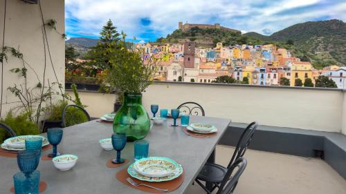 a table on a balcony with a view of a city at Bosa Eye House 1873 in Bosa