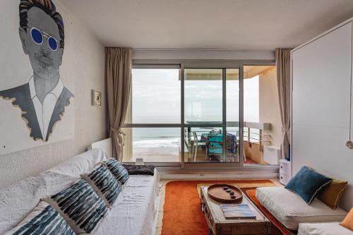 un salon avec un canapé et une vue sur l'océan dans l'établissement Studio les pieds dans l'eau à Biarritz, à Biarritz