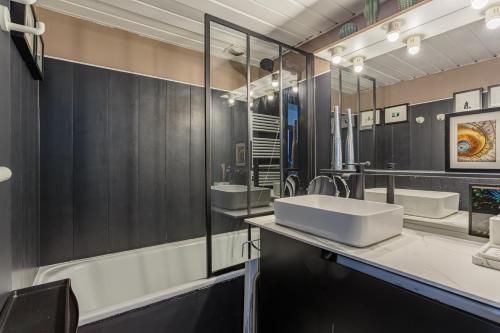 une salle de bain avec deux lavabos et un grand miroir dans l'établissement Studio les pieds dans l'eau à Biarritz, à Biarritz