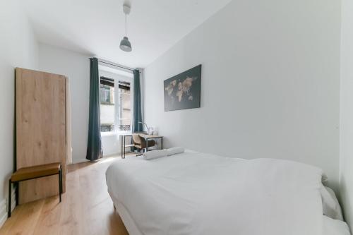 une chambre blanche avec un grand lit et une fenêtre dans l'établissement GuestReady - Old Lyon Retreat Steps from the Metro, à Lyon