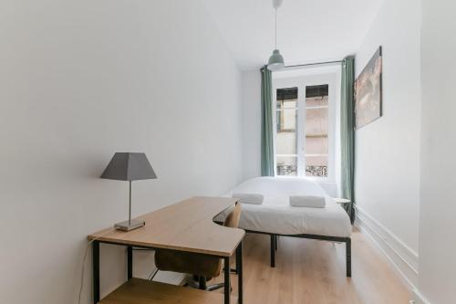une chambre avec un lit, un bureau et une fenêtre dans l'établissement GuestReady - Old Lyon Retreat Steps from the Metro, à Lyon