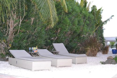 two lounge chairs and a table on the beach at Tropical villa Curoyal near the beach in Jan Thiel
