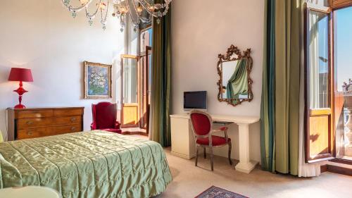 a bedroom with a bed and a desk and a mirror at Hotel Principe in Venice