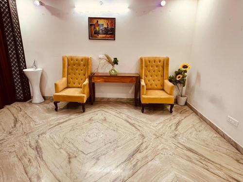 a room with two chairs and a desk and a table at JPM Suites Noida 70 in Noida