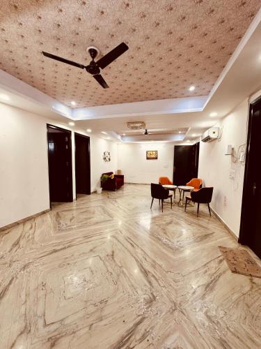 a living room with a ceiling fan and a table at JPM Suites Noida 70 in Noida