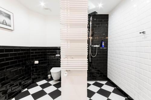a bathroom with a black and white checkered floor at LivingRoom 1 self Check-in 24h in Katowice