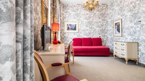 a living room with a red couch and a tv at Hotel Principe in Venice