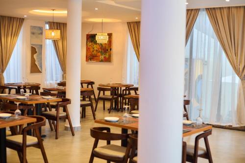 a dining room with wooden tables and chairs at AIDEN HOMES AND APARTMENTS HOTEl in Koforidua