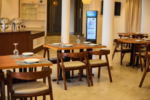 a dining room with wooden tables and chairs at AIDEN HOMES AND APARTMENTS HOTEl in Koforidua