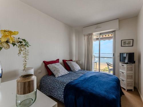 une chambre avec un lit avec une couverture bleue et une fenêtre dans l'établissement Arcachon - Accès plage, T2 avec balcon et parking - FR-1-433-2, à Arcachon
