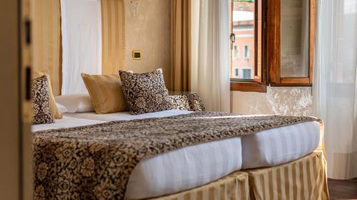 a hotel room with two beds and a window at Hotel Principe in Venice