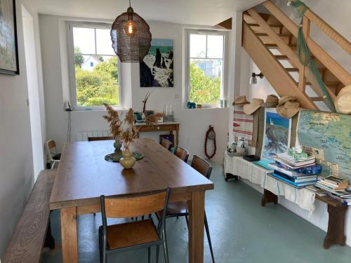 une salle à manger avec une table et des chaises en bois dans l'établissement Villa bohème chic à Sauzon avec vue mer et wifi - FR-1-418-174, à Sauzon
