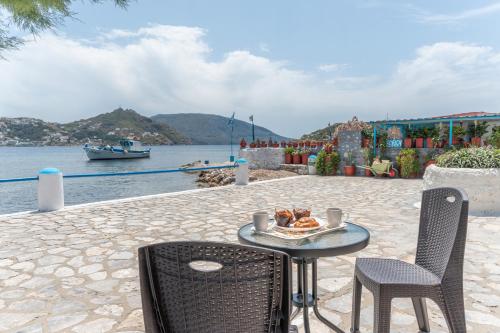 a table with a plate of food on it next to the water at Peter's Paradise in Telendos