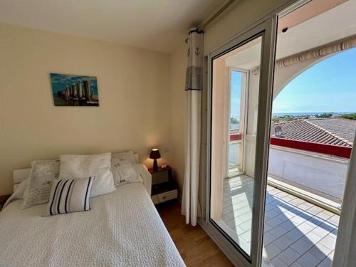 une chambre avec un lit et une grande fenêtre dans l'établissement Appart. moderne, terrasse, prêt de la plage, parking - FR-1-494-140, à Royan
