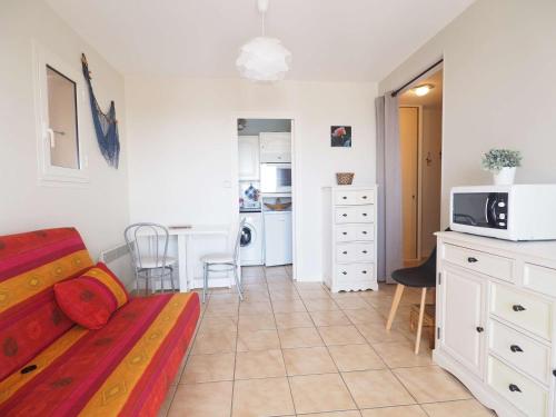 une chambre avec un lit et une cuisine avec un four micro-ondes dans l'établissement Appart. moderne, terrasse, prêt de la plage, parking - FR-1-494-140, à Royan