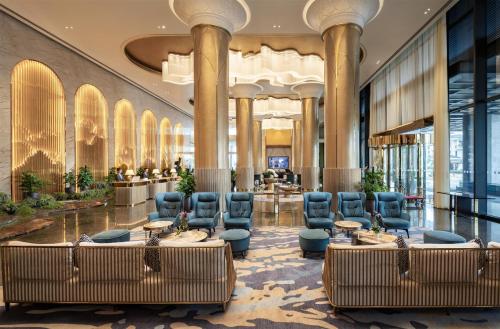 a lobby with chairs and tables in a building at Radisson Blu Ha Long Bay in Ha Long