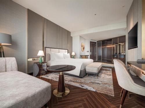 a hotel room with a bed and a living room at Radisson Blu Ha Long Bay in Ha Long