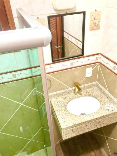 a bathroom with a sink and a mirror at Central Praias Suíte 21 in Cabo Frio