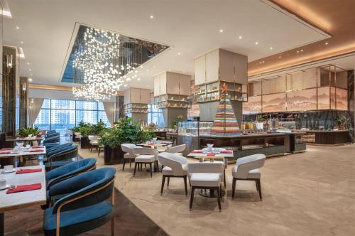 a restaurant with tables and chairs in a building at Radisson Blu Ha Long Bay in Ha Long