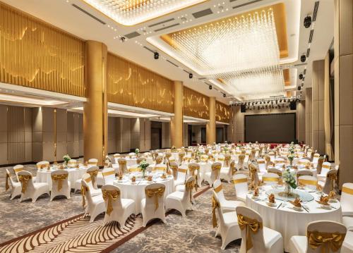 a large banquet hall with white tables and chairs at Radisson Blu Ha Long Bay in Ha Long